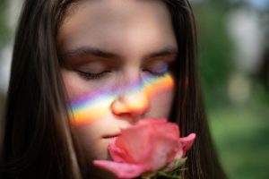 Ragazza che odora una rosa.